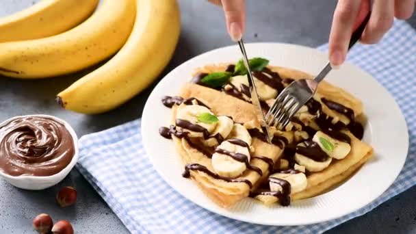 Persona Comiendo Crepes Rellenos Plátano Chocolate Untado Sabroso Desayuno Comida — Vídeo de stock