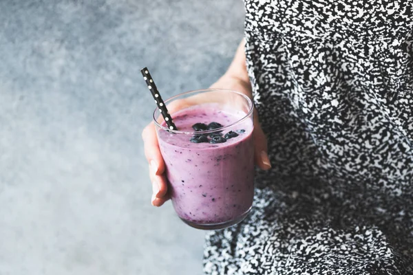 Verre de smoothie aux myrtilles dans la main des femmes — Photo