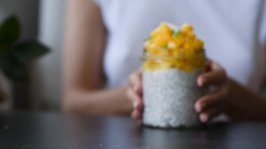 Kavanozda mango küpleri ile Chia puding. Kadın elleri chia puding ile ileri cam itin. Sağlıklı gıda, sağlıklı yaşam tarzı, temiz beslenme konsepti