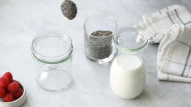 Chia puding gıda hazırlama. Dişi eller kavanoza kaşık dolusu chia tohumu koyar. Adım adım tarif