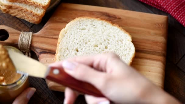 在白色三明治面包上撒花生酱 传统的美式早餐或小吃 花生酱烤面包 — 图库视频影像