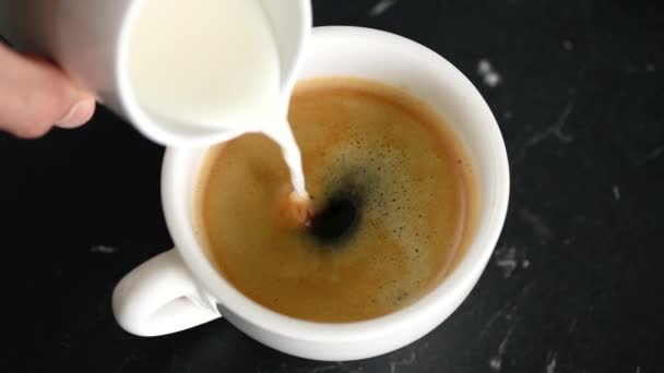 将奶油倒入一杯黑色浓缩咖啡特写镜头 — 图库视频影像