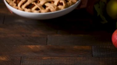 Geleneksel Amerikan sonbahar tatlısı elmalı turta. Kadının elleri tahta bir masaya taze pişmiş elmalı turta koydu