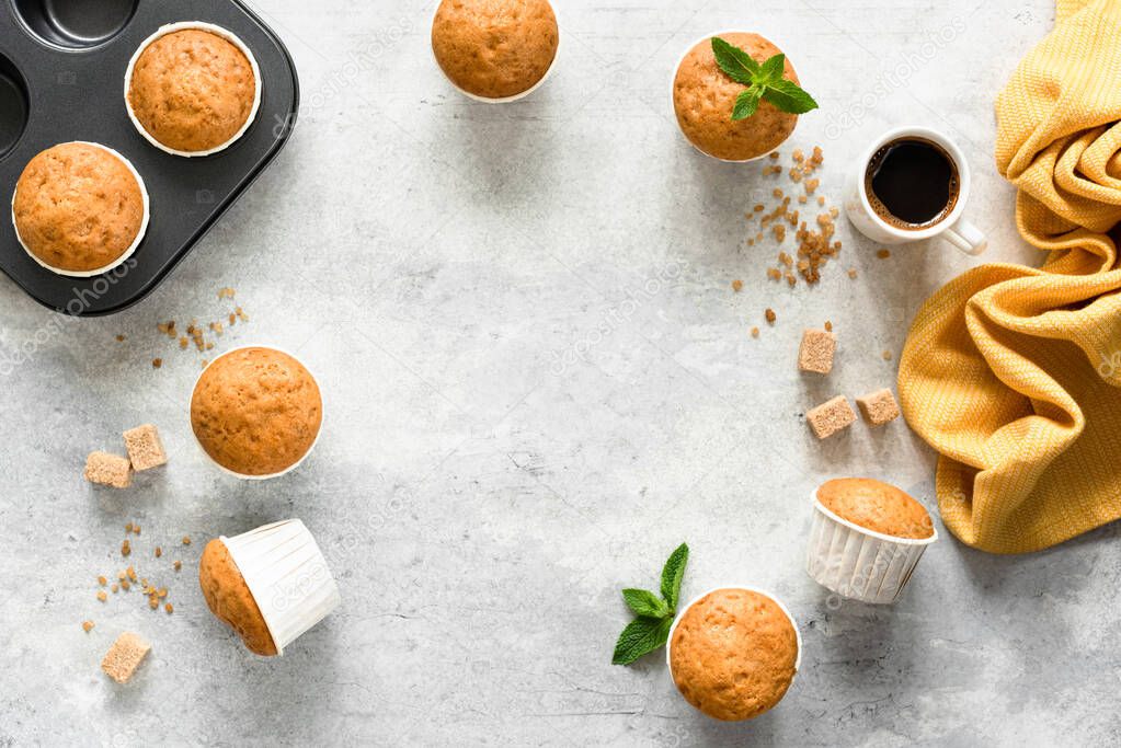 Homemade muffins in paper cups on concrete background