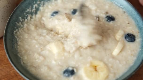 用香蕉和蓝莓搅拌早餐燕麦粥 吃健康的素食 谷类早餐 — 图库视频影像