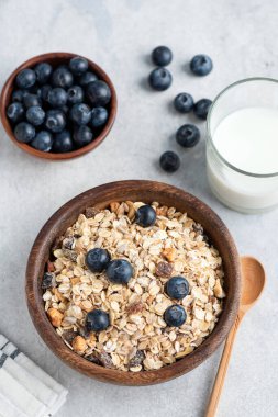 Yulaf ezmesi, yaban mersini kasesi ve beton arka planda bir bardak süt. Sağlıklı kahvaltı yemeği konsepti. Üst görünüm