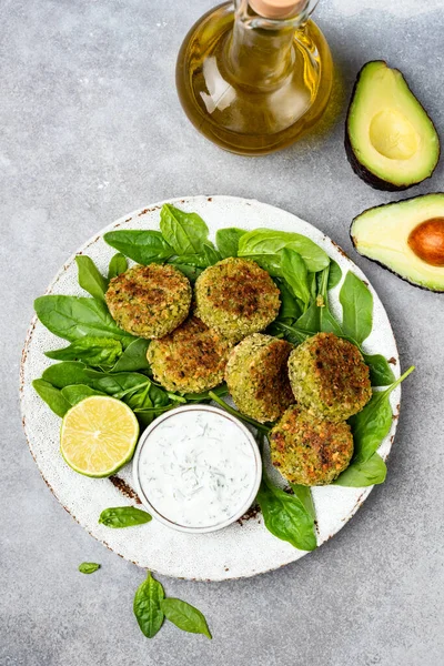 Falafel with tzatziki sauce, avocado and spinach salad. Healthy vegetarian food