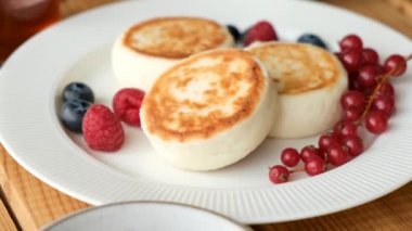 Süzme peynirli krep ya da Syrniki soslu beyaz tabakta. Rus ve Ukrayna yemekleri