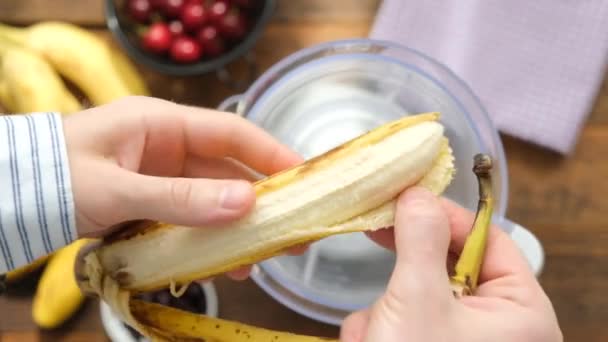 在搅拌机里准备冰沙鸡尾酒 人类剥下成熟的香蕉准备健康的水果冰沙 — 图库视频影像