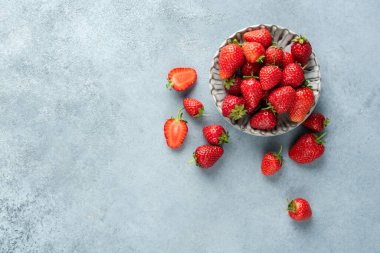Beton zemin üzerinde taze çilekler, üst görünüm, kopyalama alanı