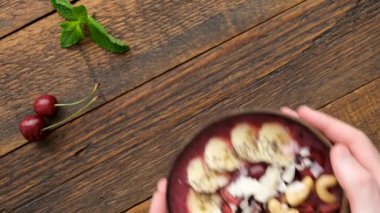 Erkek eller hindistancevizi kasesinde malzemelerle acai smoothie kasesi servis ediyor. Üst Manzara. Vegan paleo diyet konsepti