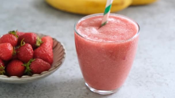 Koktajl Truskawkowy Szklanym Kubku Papierową Słomką Świeże Surowe Wegetariańskie Smoothie — Wideo stockowe