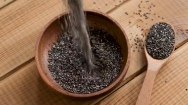 Yavaş çekim chia tohumları kaseye düşer. Omega 3 yağ asitleri bakımından zengin sağlıklı süper yiyecekler.