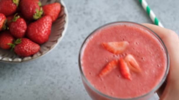 在玻璃杯中加入纯草莓沙司 手把新鲜调匀的冰沙放在桌上 — 图库视频影像