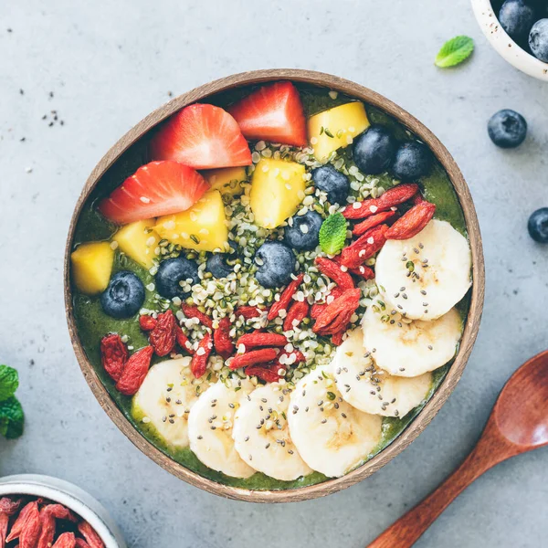 Superfood smoothie bowl with various toppings. Green smoothie. Top view, square composition