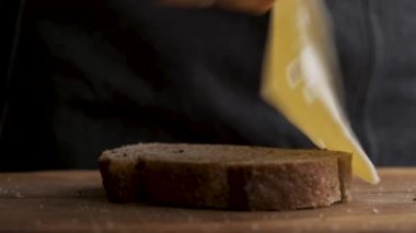 Bir dilim peynirli ekmek. Erkek eli ekmeğin üzerine bir dilim İsviçre peyniri koydu.