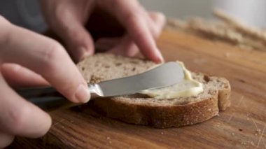 Ekmeğe organik tereyağı sürüyorum. Ekmek ve tereyağı kavramı.