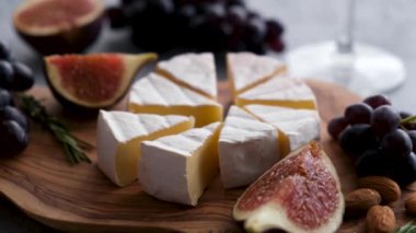 Taze incir, üzüm ve şarapla dilimlenmiş peynirli Camembert peyniri. Brie peynirini ellerimle seçiyorum.
