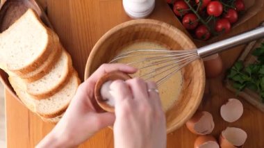 Kahvaltı omleti ya da çırpılmış yumurta hazırlamak için bir kasede tuzlu yumurta çırpmak. Üst Manzara. Kadın POV pişiriyor.