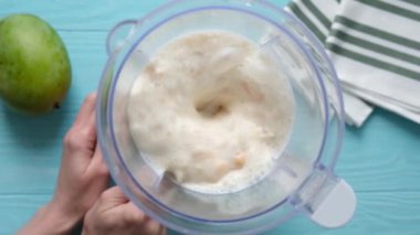 Mango milkshake veya mango lassi karışımı. Sütü mango ve muzu blender ile karıştırmanın yavaş hareketi