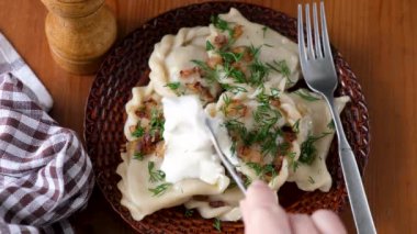 Soğanlı ve ekşi kremalı hamur tatlısı yemek. Pierogi, patates ve haşlanmış hamur tatlısı ile doldurulmuş. Polonya, Ukrayna mutfağı