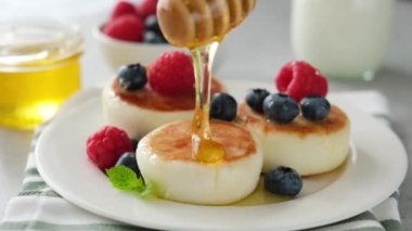 Süzme peynirli böreğin üzerine bal dökmek. Kahvaltı peynirli krep veya böğürtlen ve ballı börek.