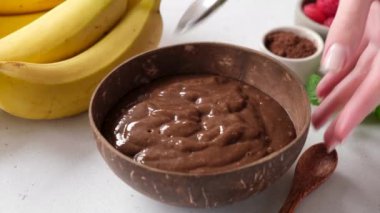 Lezzetli vejetaryen çikolatalı smoothie kasesi. Hindistan cevizi kasesinde çikolatalı smoothie servis ediyorum.