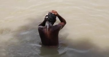 Yaşlı Hintli adam kendini yıkarken vücudunun yarısı Kolkata, Hindistan 'da Kumartuli yakınlarındaki' Ghat 'nehrinde Hooghly' Ganga 'nehrine batmış. 17 Sep 2020
