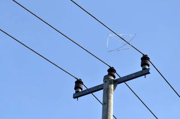 The kite frame is stuck on the electric cable