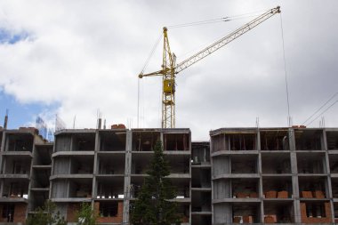 Yeni çok katlı binaların inşaatı, katların düzenlenmesi, bir vinç işi.