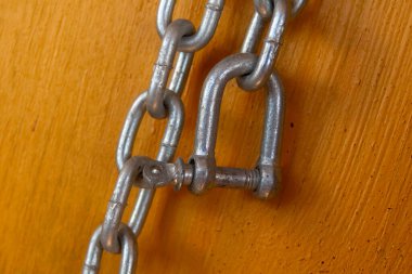 Gri renkli kalın metal zincirler, ayraçlarla donatılmış parantezler, sonunda ceketler.