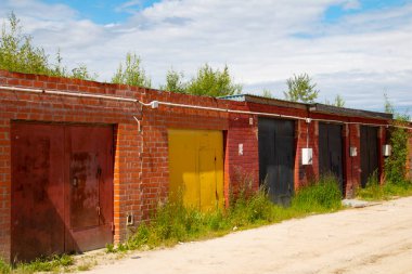 Kooperatifte metal kapıları olan tuğla bir garaj hattı.