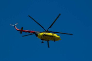 Sarı bir MI-8 tıbbi helikopter açık havada uçuyor. Hava ambulansı çalışıyor.
