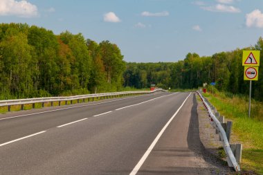 Sollama yok - sıkı dönüş! İki şeritli otoyolun kenarında tabelalar var. Önde keskin bir dönüş var. Gelen şeritte geçilmesi yasak..