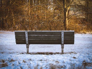 Banliyö parkında kışın bir bankın arkasında.
