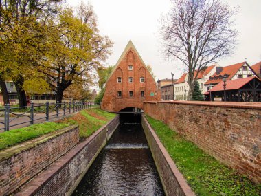 Bulutlu bir günde Gdansk 'ta kanal ve eski bir değirmen.