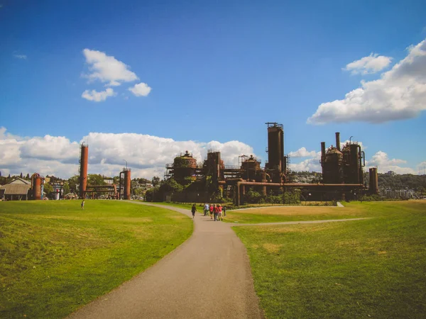 Eski endüstriyel binalar ve insanlar güneşli bir yaz gününde Seattle 'daki Gaz Fabrikası Parkı' nda yürüyorlar..