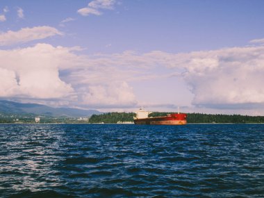Arka planda Stanley Park ve Lions Gate Köprüsü ile Vancouver 'daki kargo gemisi.