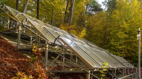 solar panels surrounded by an autumn forest