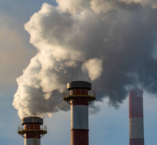 Smoking chimneys of a chemical plant emitting huge amounts of greenhouse gases.Air environment pollution concept.