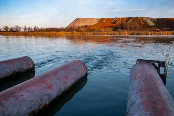 Sewage pipes discharging sewage to degraded lake