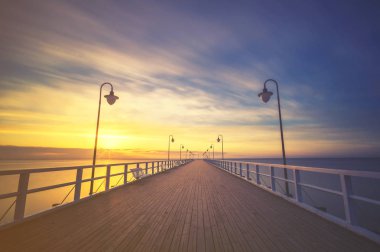 Baltık Denizi iskelede kışın gün batımında