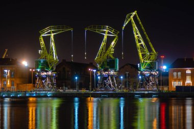 Szczecin, Polonya - Aralık 2018: Işıklı eski bağlantı noktası vinçler gece Bulvarı'nda