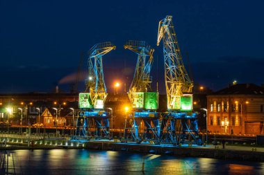 Szczecin, Polonya - Aralık 2018: Işıklı eski bağlantı noktası vinçler gece Bulvarı'nda