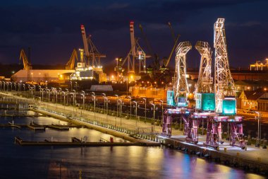 Szczecin, Polonya - Aralık 2018: Işıklı eski bağlantı noktası vinçler gece Bulvarı'nda