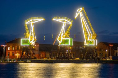 Szczecin, Polonya - Aralık 2018: Işıklı eski bağlantı noktası vinçler gece Bulvarı'nda