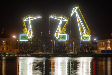 Szczecin, Polonya - Aralık 2018: Işıklı eski bağlantı noktası vinçler gece Bulvarı'nda