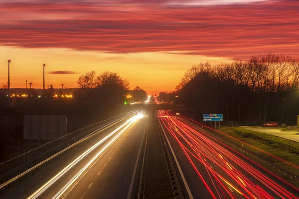 The light trails on motorway highway during a dramatic sunset — Stock Photo, Image