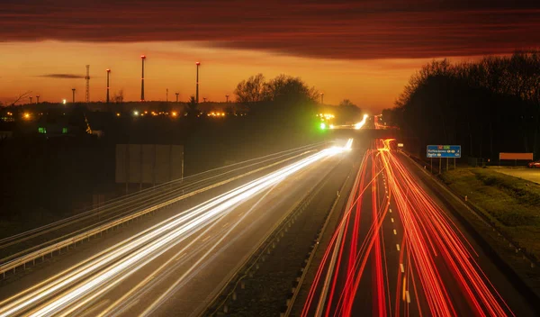 The light trails on motorway highway during a dramatic sunset — Stock Photo, Image