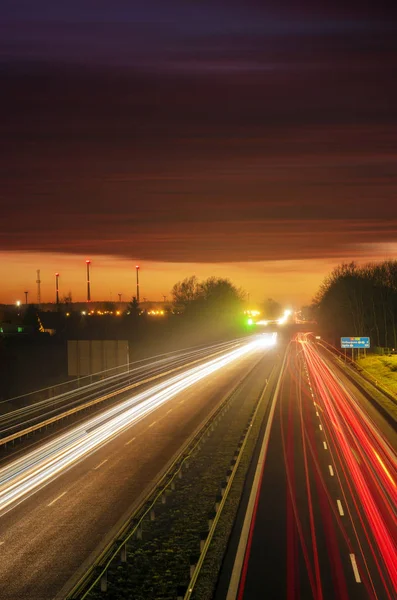 The light trails on motorway highway during a dramatic sunset — Stock Photo, Image